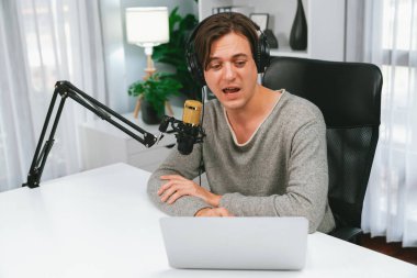 Sunucu kanalı, gülümseyen akıllı yayıncı kaydı, senaryosu ve akıllı telefonuyla sosyal medyada sohbet programı, kulaklık takarak modern ev stüdyosundaki video flamalarını kaydediyor. Bireysel.