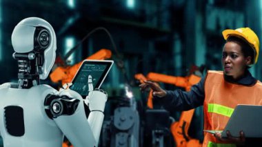 XAI Siber Endüstri Robotu ve insan işçileri gelecekteki fabrikada birlikte çalışıyorlar. Sanayi devrimi ve otomasyon üretim süreci için yapay zeka kavramı.