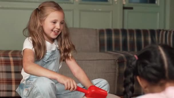 Chica Feliz Jugando Juguete Con Diversos Niños Mientras Está Sentado — Vídeos de Stock