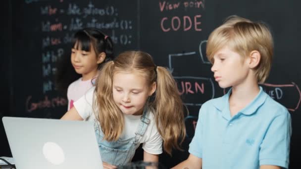 聪明的女孩使用笔记本电脑编程工程代码 带着不同的朋友 带着微晶片和主板在Stem教室里到处乱跑 黑板上写着编码器提示 Erudition — 图库视频影像