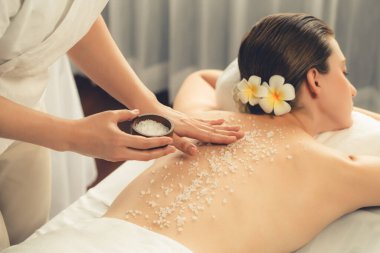 Lüks spa salonlarında sıcak mum ışığında cilt bakımı yaptıran kadın müşteri. Sağlık Spa vücut fırçasında tuz temizleme güzellik tedavisi. Sessiz.