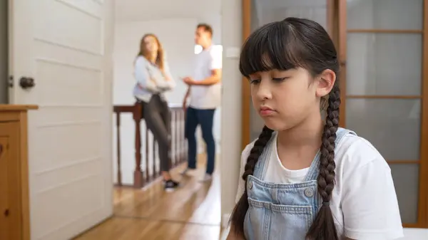 ストレスを受け 不幸な若い少女が角を曲がり 彼女の耳が彼女の親が背景で主張する音を遮断するのを隠している 自宅での家庭内暴力と外傷的な子供時代はうつ病に発展する シンクロノス — ストック写真