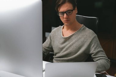 Stresli ofis çalışanı iş raporunu bilgisayar üzerine yoğunlaştırıyor, İnternet sitesi sosyal medya satış kanalına sızmayı planlayan pazar stratejisini modern ofiste promosyon yaparak analiz ediyor. Bireysel.