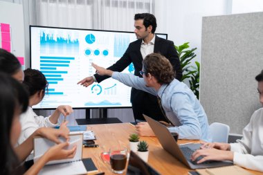 İş adamı, finansal rapor veri analizi veya pazar eğilimi gösterisiyle iş sunumunu şirketin gelecekteki yönetiminde stratejik planlama için büyük bir TV ekranında sundu. Habiliment