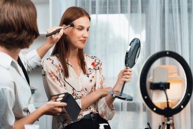 Kadın Etkilenen Vlog video görüntülerini sosyal medya ya da blog 'da en üst düzeyde yayınlıyor. Kozmetik stüdyosu ışıklandırmalı mutlu genç kız çevrimiçi pazarlama oturumu yayını için..