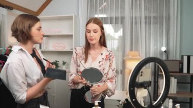 Etkilenen iki ortak canlı yayında video görüntülerini çekiyor makyaj malzemesi prim sosyal medya veya blog. Kozmetik stüdyosu ışıklandırmalı mutlu genç kız çevrimiçi pazarlama oturumu yayını için..
