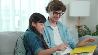 Beyaz bir baba ve tatlı bir kız kanepede otururken masal kitabı okuyorlar. Mutlu bir baba, sevimli bir Amerikan çocuğuna, birlikte zaman geçirirken hayal gücünün gelişmesi için hikaye anlatıyor. Pedagoji.