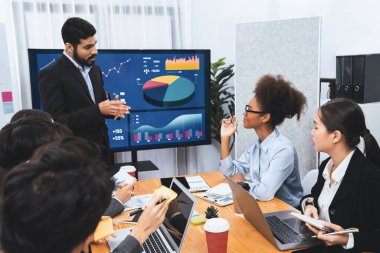 Pazarlama stratejisi için modern toplantıda veri analizi paneli ekranında sunan bir işadamı. Bir grup iş adamıyla konferans odasında iş sunumu. Uyum