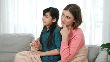 Annesi peri masalı anlatırken, mutlu kız beyaz annelerin kucağında oturuyor. Anne, kızı eve bakıp gülümserken ona sıcak bir şekilde sarılıyor. Aile birlikte vakit geçirir. Pedagoji.