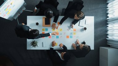 Profesyonel iş adamlarının pazarlama stratejilerinin en üst görüşü. Çeşitli iş adamları yaratıcı fikirleri yazıyor ve paylaşıyorlar. Zeki proje yöneticisi masada yürüyor ve ayakta duruyor. Müdürlük