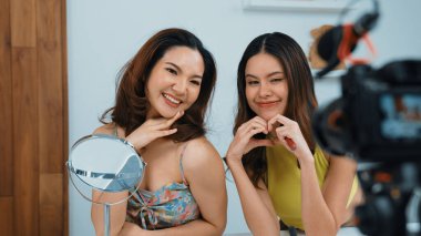 Etkilenen iki ortak canlı yayın yapan video görüntülerini sosyal medya ya da blog üzerinden gözden geçirir. Canlı kozmetik stüdyosu ışıklandırması olan mutlu genç bir kız pazarlama için internet üzerinden yayın yapıyor..