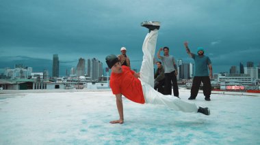 Becerikli hipster şehirde çok kültürlü dansçılarla dans ediyor. Arkadaş performans ararken çekici break dansçı çatıda sokak dansı yapıyor. Açık hava sporu 2024. ÇalışmaComment.