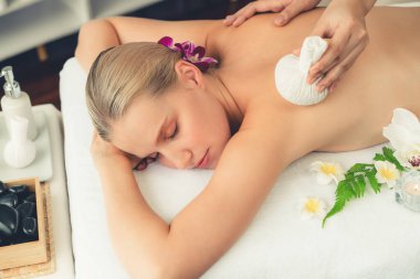 Sıcak bitkisel top spa masaj vücut tedavisi, masör kadın vücuduna nazikçe şifalı bitki torbası bastırıyor. Aromaterapi dinlenme sükuneti ve sükuneti kaplıca salonundaki atmosferi aydınlatıyor. Sessiz.