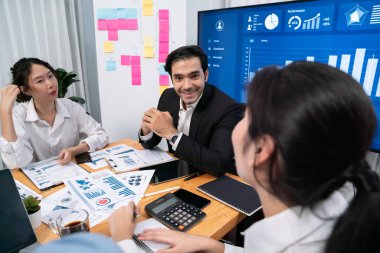 Finansal veri raporunu analiz eden çeşitli bir grup iş analisti. Mali veri analiz çizelgesi ve grafik paneli stratejik pazarlama planlama için toplantı odasında TV ekranında. Habiliment