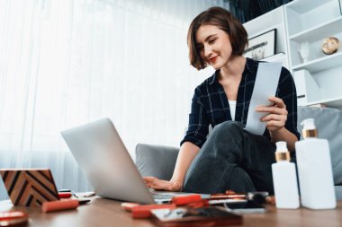 Genç mutlu kadın internetten alışveriş yaparak ürün satın alırken aynı zamanda internet üzerinden online ödeme sistemi ile çevrimiçi mağaza platformundan en yüksek siber güvenlik tarafından korunan ürünler sipariş ediyor.