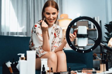 Kadın Etkilenen Vlog video görüntülerini sosyal medya ya da blog 'da en üst düzeyde yayınlıyor. Kozmetik stüdyosu ışıklandırmalı mutlu genç kız çevrimiçi pazarlama oturumu yayını için..