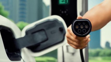Kameranın önüne odaklanmış EV şarj cihazı fütüristik akıllı dijital EV batarya durum hologramını gösteriyor. EV araba şarjı sürdürülebilir güç için alternatif enerji kullanıyor. İnceleyin