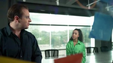 Profesyonel iş adamları yaratıcı pazarlama fikrini modern ofiste tartışırlar. İş adamları cam tahtada yapışkan notlar kullanarak finansal plan üzerinde çalışıyor. Yönlendirici.