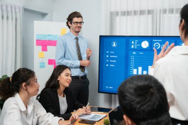 İş adamı, finansal rapor veri analizi veya pazar eğilimi gösterisiyle iş sunumunu şirketin gelecekteki yönetiminde stratejik planlama için büyük bir TV ekranında sundu. Habiliment