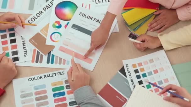 顶部视图慢动作手特写在两个设计师的桌子上 为平面设计工作选择颜色 或客户在设计师创造性的色彩咨询中寻找颜色应用 — 图库视频影像