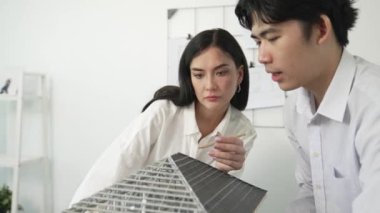 Ev inşaatını işaret edip tartışırken mimari teçhizat kullanarak birlikte çalışan profesyonel mühendis ekibinin yakınlaşması. Yaratıcı karar ve takım çalışması konsepti. Tertemiz..