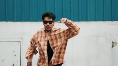 İspanyol komedi koreografı hip hop tarzında dans ediyor. Genç mutlu break dansçı B-boy dansı yapıyor. Sokak dansı yapan komik adamın hareket çekimi. Açık hava sporu 2024. Modern dans. hiphop.
