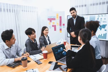 Pazarlama stratejisi için modern toplantıda veri analizi paneli ekranında sunan bir işadamı. Bir grup iş adamıyla konferans odasında iş sunumu. Uyum