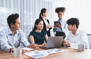 Çok ırklı analist ekibi toplantı masasındaki mali raporu analiz etmek için BI gösterge tablosunu kullanıyor. Çeşitli iş adamlarından oluşan bir grup, FIntech 'in veri analizini başarılı iş pazarlaması için kullanır. Uyum