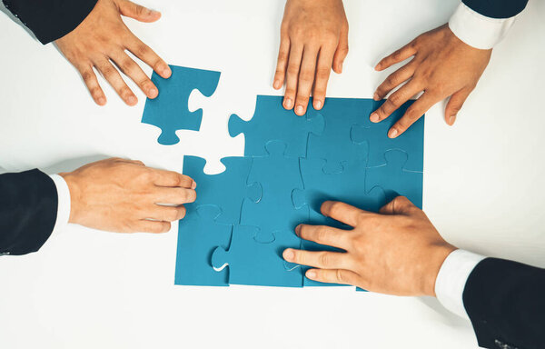 Панорамный баннер бизнес-команды, собирающей пазл за столом, символизирует деловое партнерство и коллективную командную работу по подбору персонала и поиску работы. Shrewd