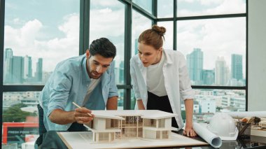 Kooperatif mimar mühendis ekibi kalem kullanarak ev modelini ölçmek için birlikte çalışıyor. Başarılı bir Kafkas iç mimari tasarım ekibi mimari model yapısını inceliyor. Tasarım. İzleme