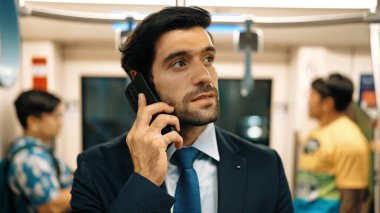 Zeki bir iş adamı trendeyken proje yöneticisini arıyor. Profesyonel erkek lider, geçmişi bulanık telefon kullanarak yatırımcıyla pazarlama planı hakkında konuşuyor. Sevinçli..