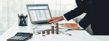 Kurumsal muhasebeci, vergi iadelerini hesaplamak ve maksimuma çıkarmak için dizüstü bilgisayar üzerinde muhasebe yazılımı kullanır ve Panorama 'daki iş yatırım yığını madeni para konseptiyle finansal performansı artırır. Kurnaz.