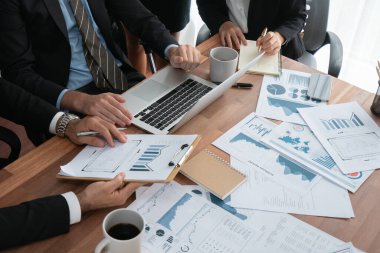 Ofis masasındaki finansal veri raporlarını analiz eden çeşitli bir grup iş analisti. Stratejik pazarlama planlaması için iş istihbarat analizine göre grafikler ve grafikler.