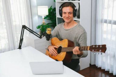 Akıllı şarkıcı görünümlü kamerada sunucu kanalı, şarkı söylerken gitar çalmak, sosyal medya kanalında yayın yapmak, modern stüdyo kaydında video kaydedici olarak kulaklık takmak. Bireysel.