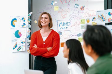 Profesyonel çekici kadın lider, modern iş toplantı odasında beyin fırtınası zihin haritalama istatistikleri ve renkli yapışkan notlar kullanarak yaratıcı pazarlama planını sunuyor. Tertemiz..