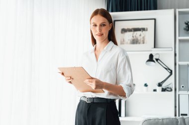 Klinikteki psikolog kadın. Profesyonel portresi. Dostane gülümsemesiyle hastayı psikoloğa davet ediyor. Tecrübeli ve kendine güvenen psikolog son derece uzmandır.