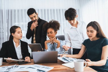 Çok ırklı analist ekibi toplantı masasındaki mali raporu analiz etmek için BI gösterge tablosunu kullanıyor. Çeşitli iş adamlarından oluşan bir grup, FIntech 'in veri analizini başarılı iş pazarlaması için kullanır. Uyum