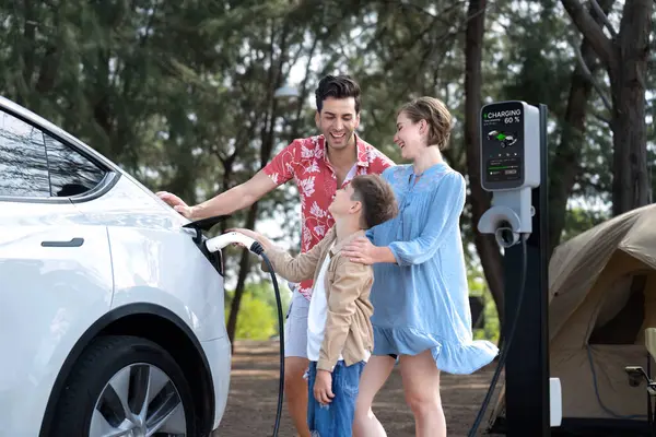 アウトドアアドベンチャーと家族旅行キャンプ 持続可能な未来のためのエコフレンドリーな車で自然旅行 キャンプ場のEv充電ステーション付きの素敵な家族の充電Ev車 パーペチュアル — ストック写真