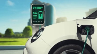 Yeşil Şehir Parkı 'ndaki ekolojik temiz enerji şarj istasyonundan gelen fütürist akıllı EV şarj aletinin şarj ettiği elektrikli araba. Alternatif enerji kullanan gelecekçi elektrikli araba. İnceleyin