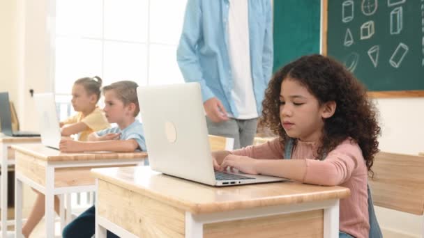 コーカサス教師は アメリカの学生コーディングエンジニアリングのプロンプトを支援しながら ソフトウェア生成Aiを使用して多様な学生を支援しています スマートな魅力的な子供たちが座ってプログラミングシステム 教育について ペダゴロジー — ストック動画