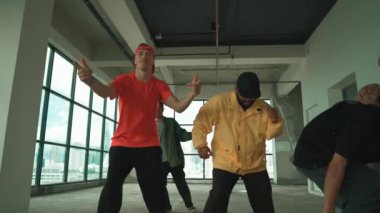Çok kültürlü dansçılar sokak dansı yapıyor ve hip-hop müziğine geçiyorlar. Profesyonel hipster grubu gökyüzü kavgacı görünümlü bir binada serbest stil müzik eşliğinde dans ediyor. Açık hava sporu 2024 hiphop..