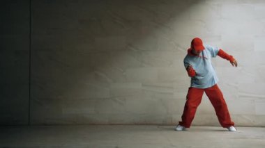 Profesyonel Asyalı hipster gri arka planlı break dansçı performansı sergiledi. Çekici bir sokak dansçısı şık kıyafetler giyerken hareketli hareketler yapar. Açık hava sporu 2024. Uzayı kopyala Yumuşak bir şekilde..