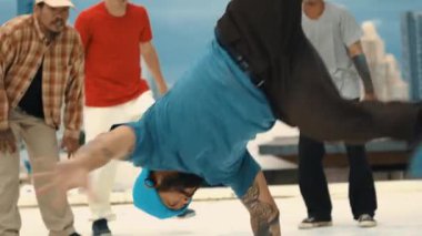Profesyonel Asyalı sokak dansçısı çatıda çok kültürlü arkadaşlar dans ederken B boy dansı yapıyor. Genç modern dans grubu hip hop hareketi yapıyor. Tarz, moda, aksiyon. Açık hava sporu 2024 hiphop..