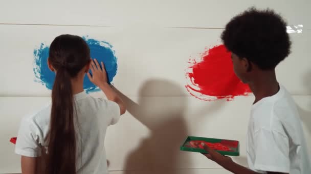 Diversa Menina Ensino Médio Feliz Menino Africano Pintar Parede Com — Vídeo de Stock