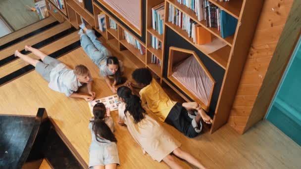 Grupp Olika Barn Som Ligger Cirkel Medan Läser Bok Biblioteket — Stockvideo