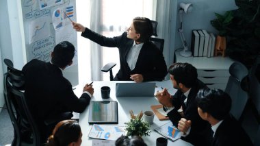 Akıllı yöneticinin üst görünümü, kurul ve kağıt arasındaki grafiği karşılaştırırken aynı zamanda başlangıç projesini iş toplantısında çeşitli takımlardan oluşan bir grupla birlikte planlıyor. Beyin fırtınası yapan ve birlikte çalışan takım. Müdürlük.