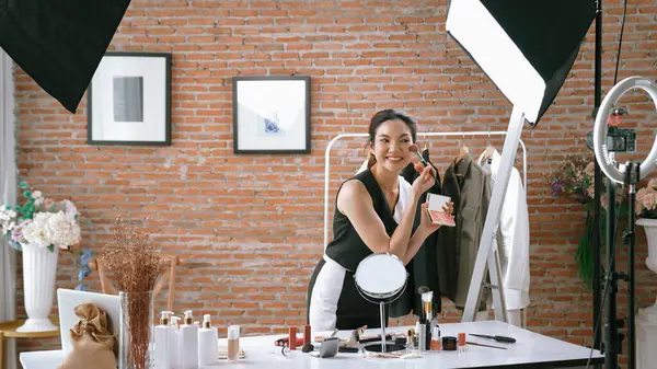 Woman influencer shoot live streaming vlog video review vivancy makeup social media or blog. Happy young girl with cosmetics studio lighting for marketing recording session broadcasting online.
