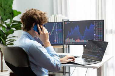 Başarılı genç yatırımcı, akıllı telefondan iş ortağına Dinamik Finansal Değişim Yatırım Dizüstü bilgisayarı ile modern ofisteki mevcut pazar grafiğinde gerçek zamanlı arıyor. Toplayıcı.