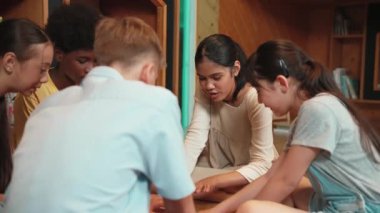 Bir grup farklı çocuk kütüphanede kitap okurken daireler çiziyor. Liseli kız bir dergiyi paylaşırken ilgili konulara dikkat çekiyor ve çok kültürlü arkadaşlarla konuşuyor. Öğretim