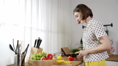 Çekici beyaz anne salata yapmak için taze sebze doğruyor. Mutlu enerjik akıllı anne kahvaltıda sağlıklı yemek pişirirken modern mutfakta çalışıyor. Yemek hazırlama konsepti. Pedagoji.